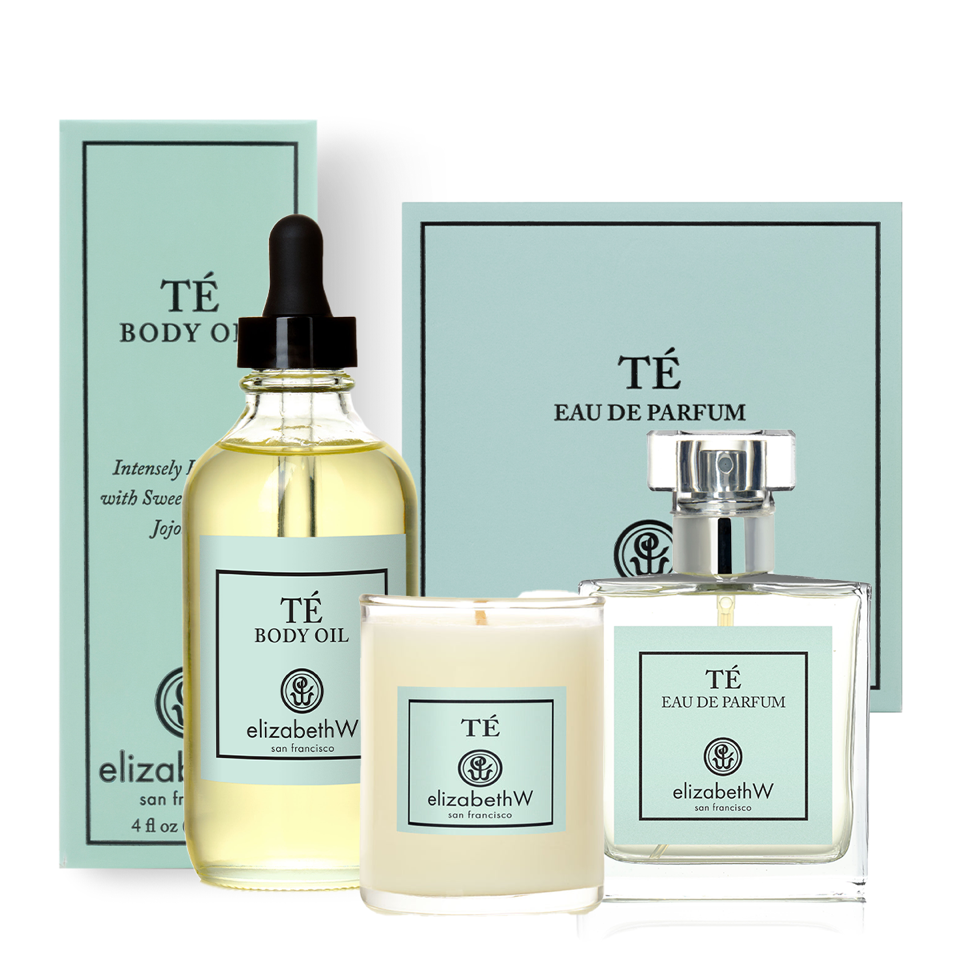The elizabethW Té Body Bundle displays four oriental black tea scented products—a moisturizing body oil with dropper, candle, and eau de parfum—in front of matching blue boxes on a white background.