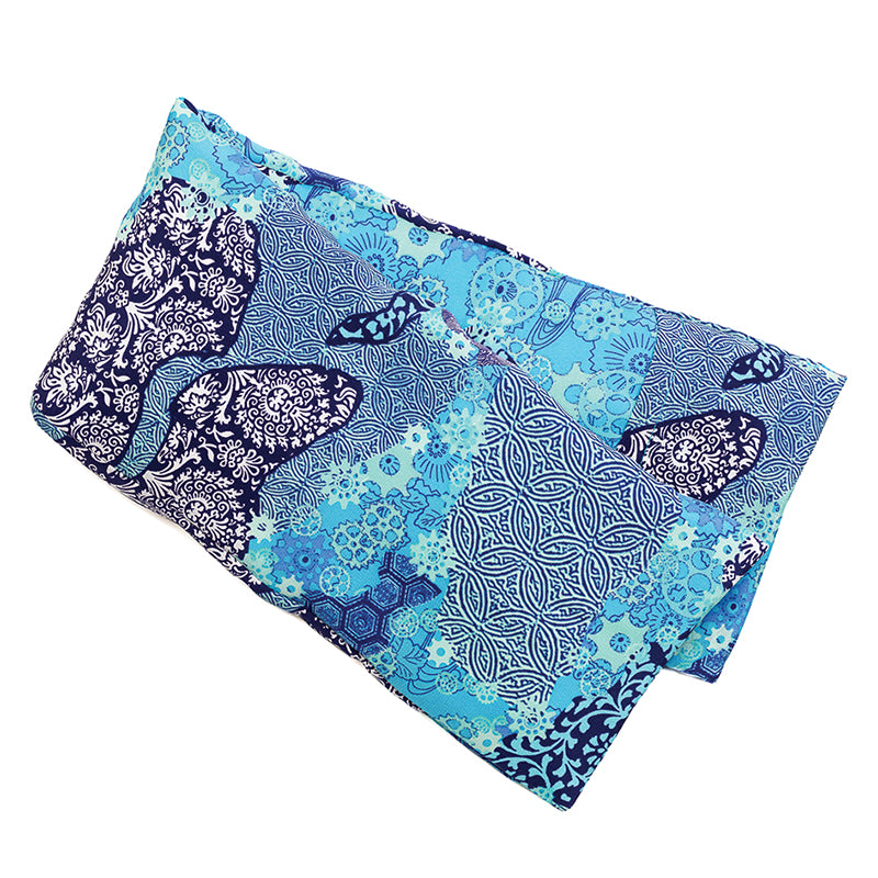 Neatly arranged against a plain white background, the elizabethW Aqua Origami Hot/Cold Flaxseed Pack, is covered in a silk casing. Displays a variety of intricate patterns and designs with dominant shades of blue complemented by white accents. Can be used as a heat pad or cold compress. 