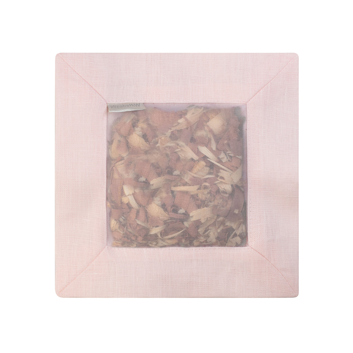 Cedar filled inside of a pink colored square sachet with a transparent screen
