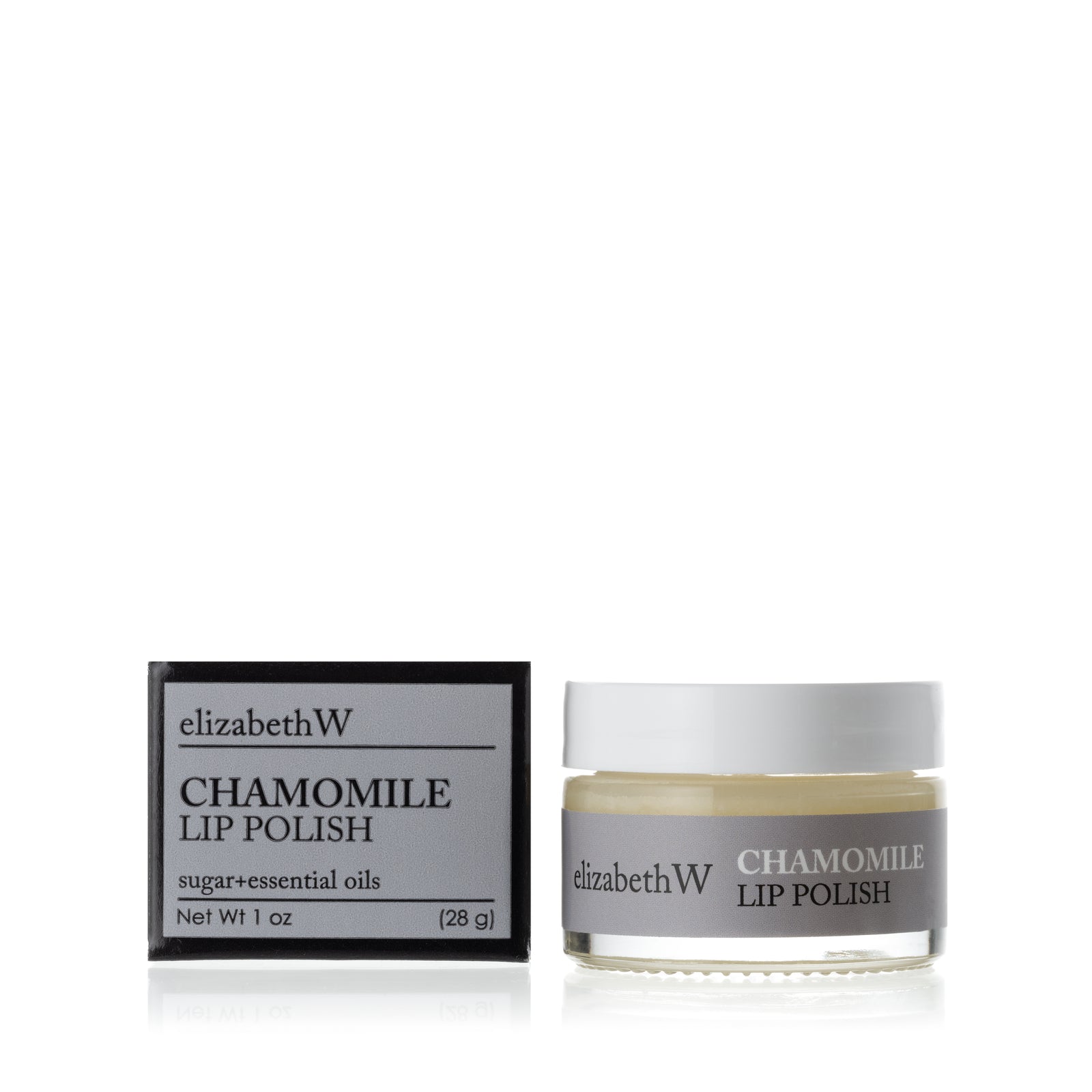 A glass jar of Chamomile Lip Polish beside its matching black and gray box. The jar contains a smooth white lip polish with a gray label.