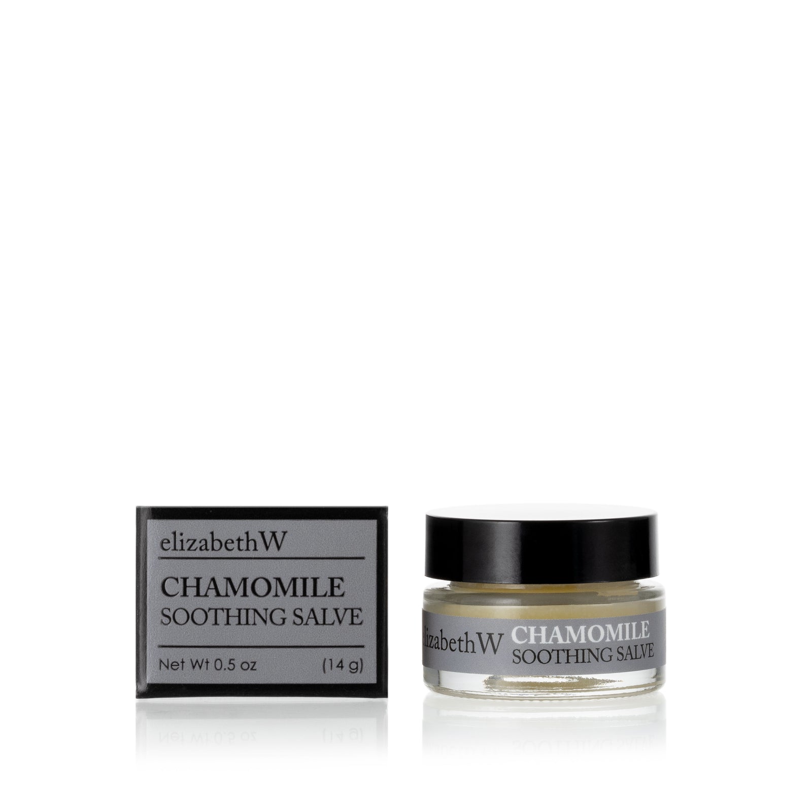 .5 oz (14g) glass jar of Chamomile Soothing Salve with a matching gray and black box. The jar contains salve, and the box displays the product name and the brand elizabethW in black text on a gray background.