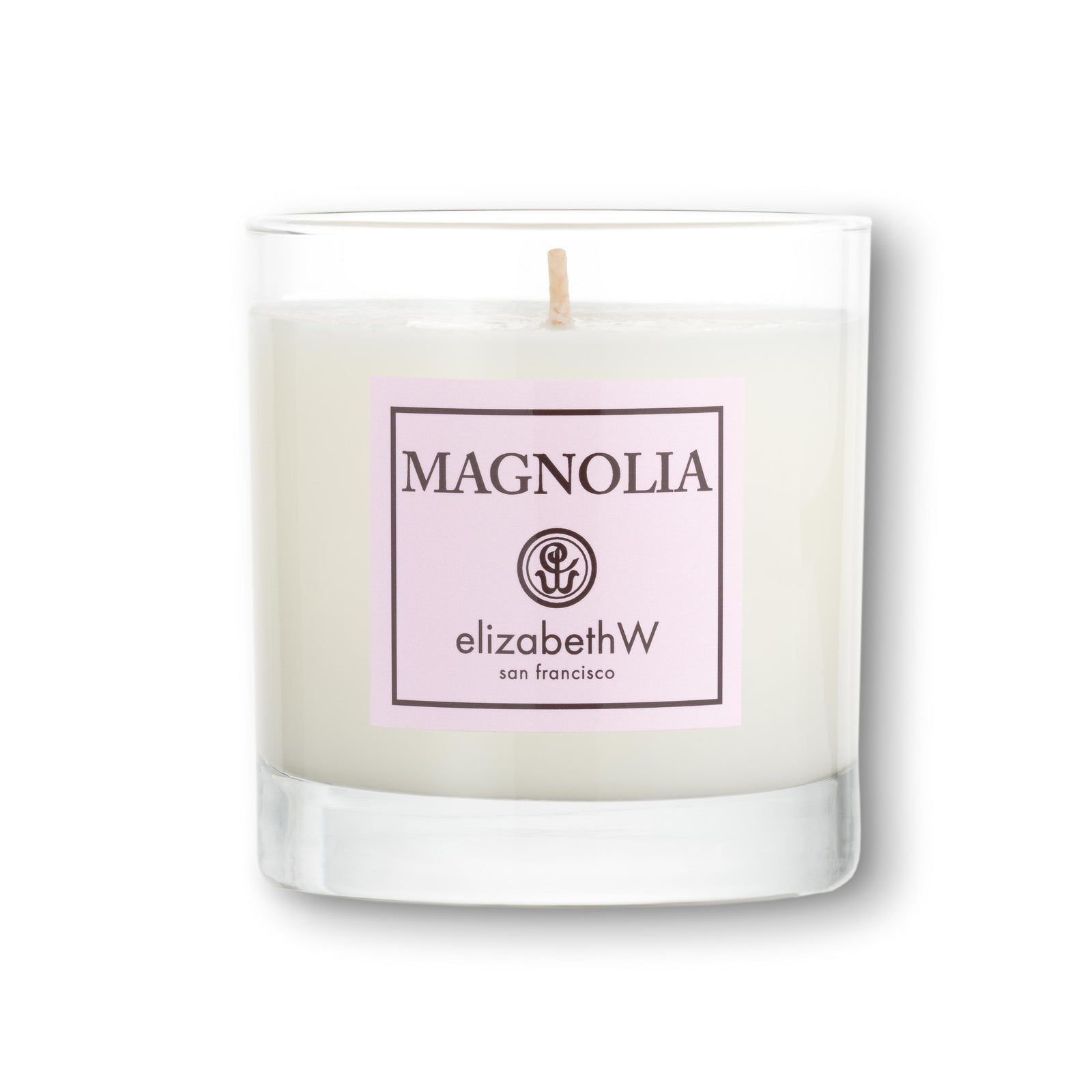 A white 8 oz (227 g) candle in a clear glass container with a single wick. The soft pink color label on the front reads "Magnolia" with the elizabethW logo and "san francisco."