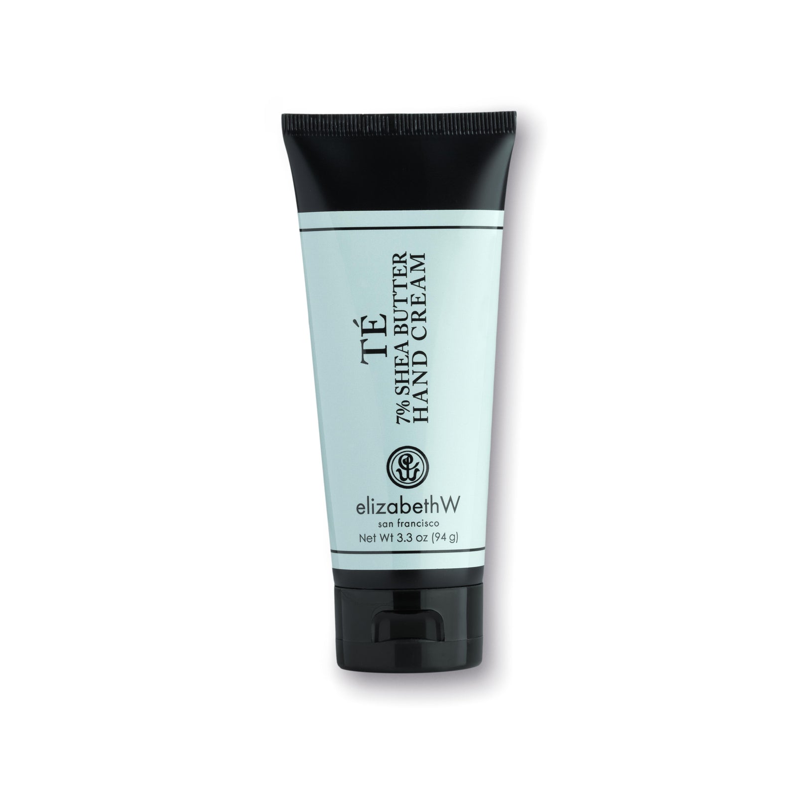 A 3.3 oz (94 g) teal-colored tube of TE hand cream with a black cap and black text. The label reads "TE 7% Shea Butter Hand Cream," with the elizabethW logo and "san francisco" beneath it. The net weight of the product is also listed on the label.