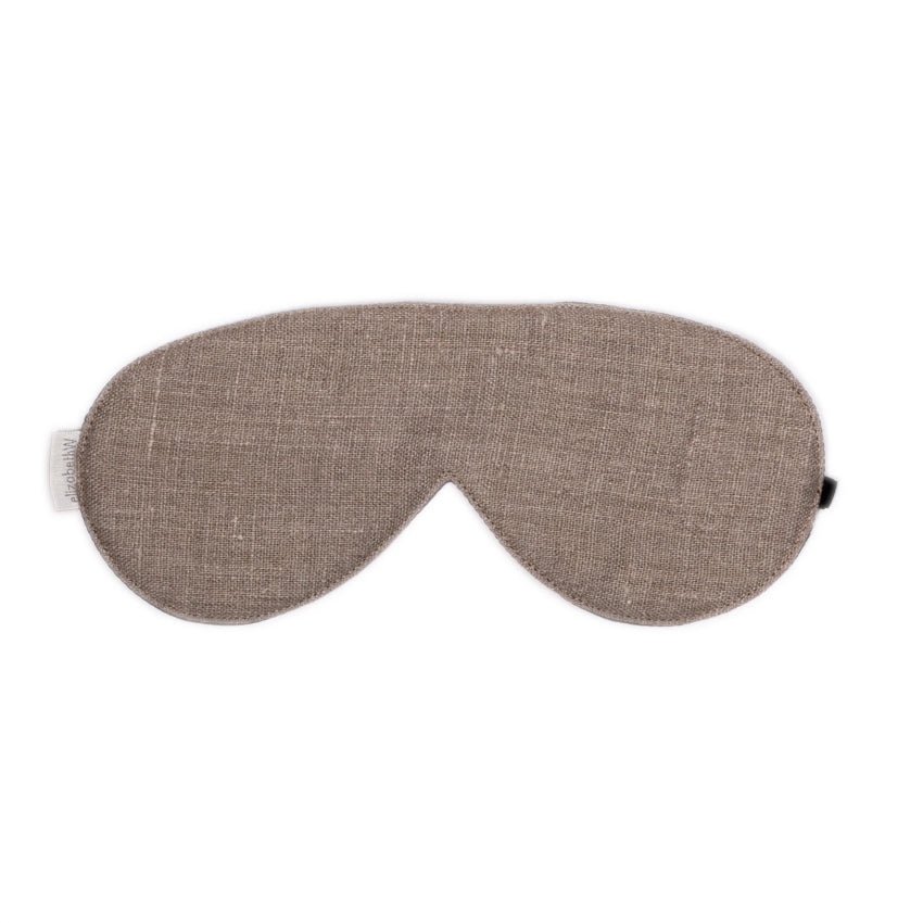 The Washed Natural Linen Sleep Mask by elizabethW, made from linen-like fabric in a light brown hue. It includes adjustable strap to ensure it secures comfortably around your head for a restful sleep. 