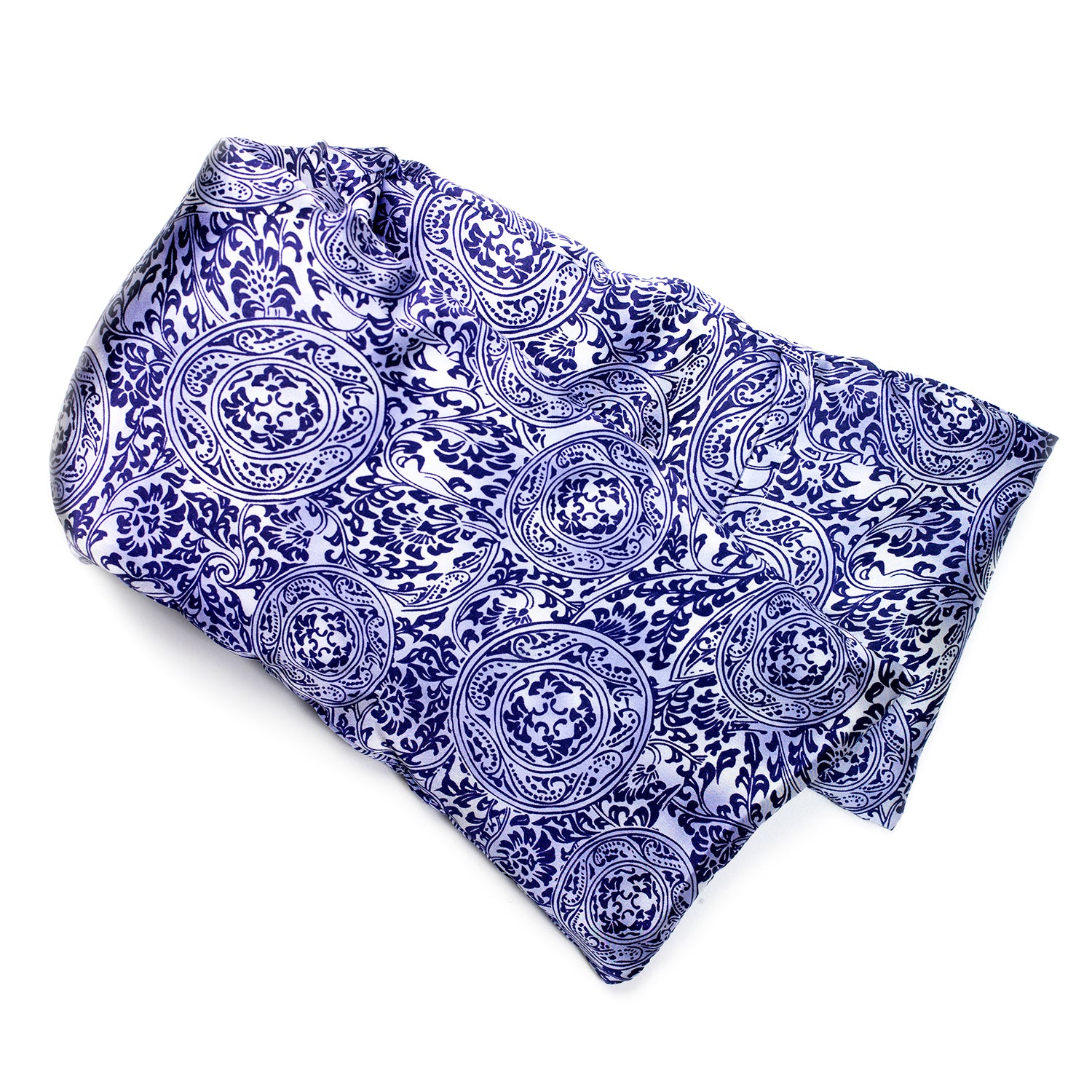 Neatly arranged against a plain white background, the elizabethW Venetian Blue Hot/Cold Flaxseed Pack is covered in a silk casing displaying dark floral and circular patterns, and can be used as a heat pad or cold compress.